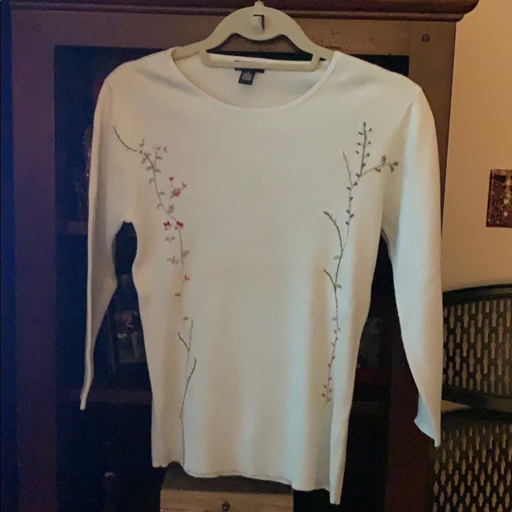 Soft blue knit with embroidered floral detail.